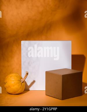 Abstrakte Herbstkomposition mit Würfelpodium und Danksgiving-Kürbisdekor. Produktbühnen-Display für halloween-Konzept. Minimales Design mit Stockfoto
