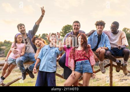 Fröhliche, generationenübergreifende Gruppe von Freunden und Familie, die im Freien feiern. Verschiedene Menschen unterschiedlichen Alters und Ethnien genießen die gemeinsame Zeit in na Stockfoto