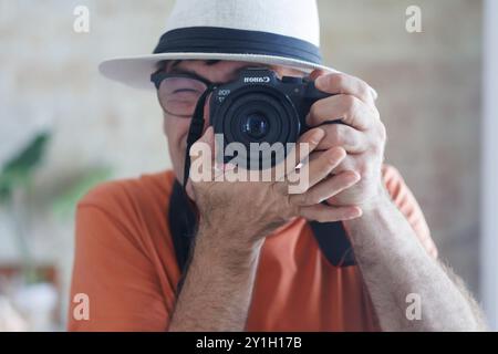 Selbstporträt im Spiegel mit Kamera und Hut. Los Arenales del Sol, Spanien Stockfoto