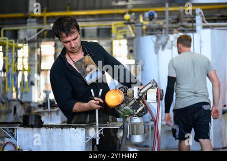 Karlovy Vary, Tschechische Republik - 11. August 2024: Meister des Glasbläsers oder Gaffers, der mit heißgeschmolzenem Glas in der Fabrik Moser arbeitet. Stockfoto