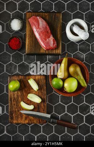 Auf Holzbrettern liegen verschiedene frische Zutaten, darunter rohes Fleisch, lebendige Äpfel und Birnen, die in ein Gourmetgericht verwandelt werden können Stockfoto