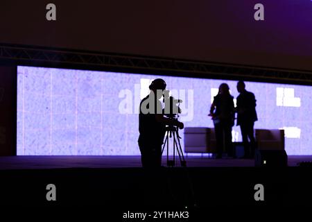 Schwarze Silhouetten von Menschen - der Kameramann nimmt das Interview vor der Kamera auf Stockfoto