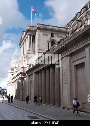 Bank of England Threadneedle Street, an der Fußgänger vorbeilaufen, und Union Flag Union Jack oben auf dem Gebäude Stockfoto