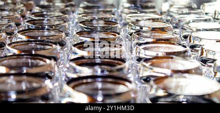Eine Nahaufnahme der zahlreichen Glasgefäße, die in einem Gittermuster angeordnet sind und ihre glänzenden Oberflächen und Reflexionen zeigen. Die Gläser haben ein modernes Design und Stockfoto