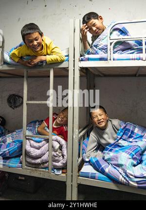 (240907) -- LHASA, 7. September 2024 (Xinhua) -- Konchog Rapten (R, unten) und seine Mitbewohner unterhalten sich in ihrem Schlafsaal der Zentralen Grundschule in Nyangpo Township im Gongbo'Gyamda County, Nyingchi, südwestchinesische Autonome Region Xizang, 3. September 2024. Konchog Rapten ist ein 10-jähriger Junge, der in der fünften Klasse an der Central Primary School im Gongbo'Gyamda County, Nyingchi, studiert. Seine Schule, die auf einer Höhe von fast 4.000 Metern liegt, ist die höchste Schule im County. Die Schule ist gut ausgestattet mit modernen Einrichtungen, einschließlich Unterrichtsräumen mit interaktivem Touchscreen Stockfoto