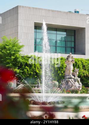 Salzburg, Österreich - 31. August 2024: Ein optisch fesselnder Steinbrunnen mit einer komplizierten Statue als Herzstück vor der modernen Fassade von A Stockfoto