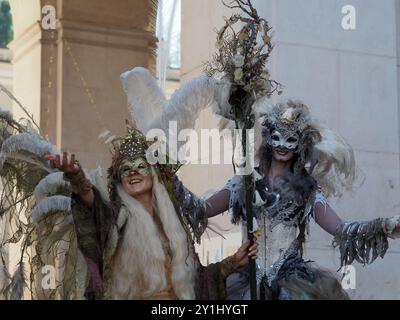 Salzburg, Österreich - 31. August 2024: Zwei Personen in aufwendigen Festkostümen mit großen gefiederten Kopfstücken und verzierten Accessoires posieren Stockfoto