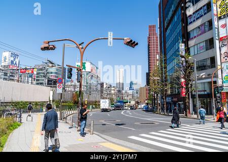 Blick auf die Shinjuku dori, Straße, an einem heißen Frühlingstag. Die Bahnstrecke verläuft entlang des Bahnhofs mit Hochhäusern auf der anderen Seite. Tokio. Stockfoto