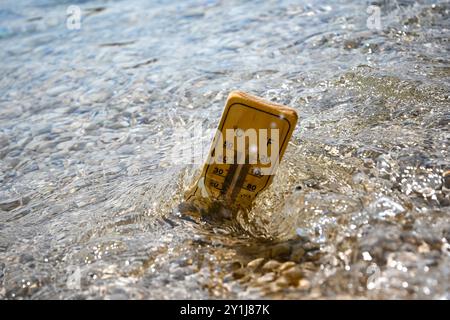 Holzthermometer zur Messung der steigenden Temperatur des Meerwassers während der Hitzewelle. Stockfoto