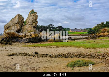 Alte einsame Steinfarm. Aus der Ferne mit einem Meereseingang im Vordergrund und an einem teilweise sonnigen Sommertag, Brehat Island, Bretagne, Frankreich. Stockfoto