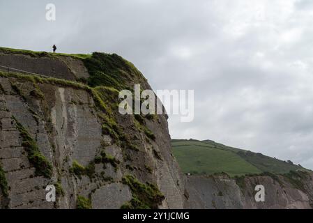 Mann am Rande einer Klippe in Zumaya im baskenland. Beobachten Sie die Flysch ibilbidearen hasiera von Itzurun. Stockfoto