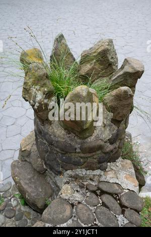 An der Station auf der Spitze der Artxanda-Standseilbahn in Bilbao können Sie diese seltsame Vase aus Felsen am Fuße einer Treppe sehen: Gras wird gezüchtet. Stockfoto