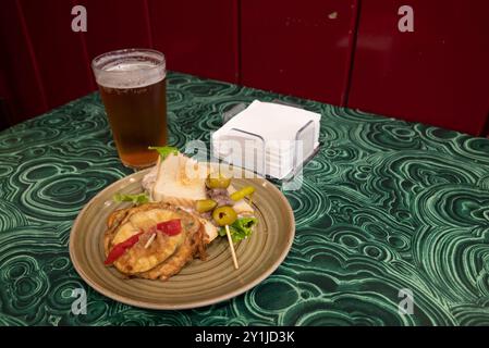 Köstliche spanische Pintxos mit Schinken, Oliven, grünem Pfeffer, Omelette, Krabben, Kabeljau und Mayonnaise. Typisch für das Baskenland im Norden Spaniens. Stockfoto