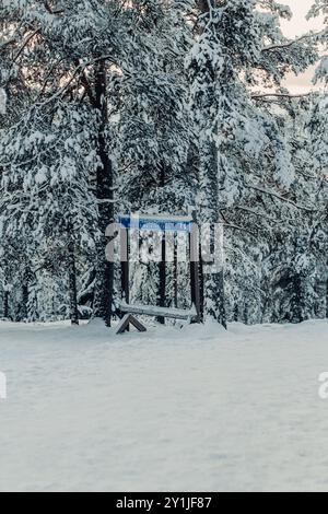 Schild für den Winterwanderweg in Ounasvaara im verschneiten Wald in Rovaniemi, Lappland Stockfoto