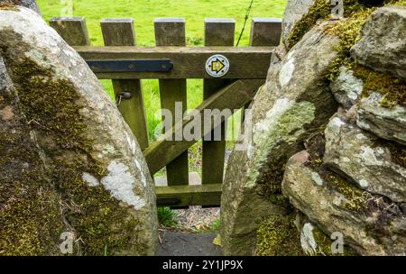 Enge Stile mit Holztüren sind typisch für Fußwege der Yorkshire Dales. Dieser ist als Teil des Pennine Way markiert. Stockfoto