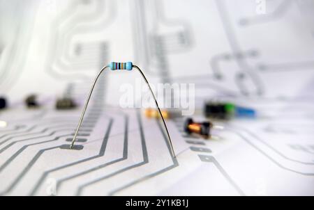 Einzelner elektrischer Widerstand auf verschwommenem Schaltplanhintergrund. Konzeption, Projektierung und Produktion elektronischer Systeme. Schwerpunkt auf Resi Stockfoto