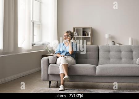 Glückliche ältere Frau, die auf ihrem Smartphone spricht Stockfoto