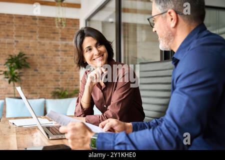 Zwei Führungskräfte arbeiten am Laptop und diskutieren Dokumente bei einer Besprechung im Büro. Stockfoto