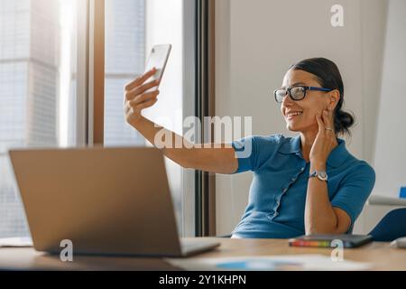 Eine Frau führt ein lebhaftes Videogespräch, während sie von zu Hause aus arbeitet Stockfoto
