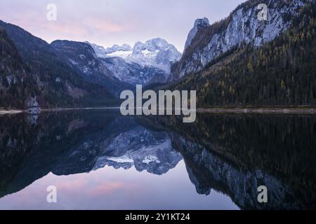 Der vordere Gosausee im Herbst mit Blick auf die Dachsteinkette. Der Gosaukamm ist rechts. Wolken am Himmel, Sonnenaufgang. Vorderer Gosa Stockfoto