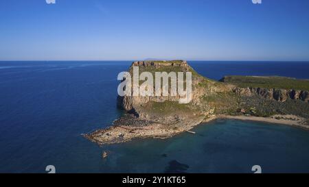 Drohnenaufnahme, felsige Klippenküste mit benachbartem Strand und klarem blauem Himmel über dem weiten Ozean, venezianische Meeresfestung, Gramvoussa Halbinsel Stockfoto