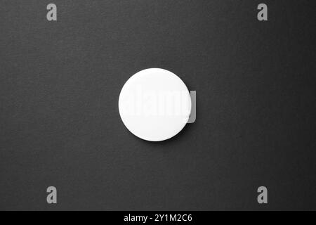 Leeres weißes Knopfabzeichen auf schwarzem Hintergrund, Draufsicht. Modell für Design Stockfoto
