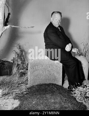 1960 c. , USA : der gefeierte Filmregisseur ALFRED HITCHCOCK ( 1899–1980), Publizitätsstill für die Veröffentlichungswerbung von TV Serial ALFRED HITCHOCH PRÄSENTIERT ( CBS TV , 1955–1962 ). In jeder Episode erschien Hitchcock am Anfang als Moderator, um die Handlung der Episode vorzustellen und am Ende wieder aufzutauchen, indem er einen Glanz mit einer „moralischen“ Schlussfolgerung in einer absurden, makabren, lustigen und völlig surrealen Art wie in seinem Stil versetzte. Das Foto zeigt ihn in einem dieser Momente auf einem Grabstein sitzend, auf dem die Schrift ALFRED HITCHCOCK R.I.P. ( ZUMINDEST VORERST ) steht. Unkn Stockfoto