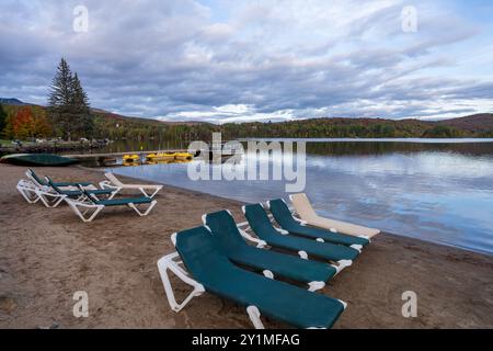 Liegestühle am Seeufer. Lake Ouimet (Lac Ouimet) Herbstlandschaft. Mont-Tremblant, Quebec, Kanada. Stockfoto