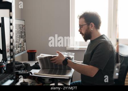 Professioneller Fotograf, der Fotos im Heimstudio überprüft Stockfoto