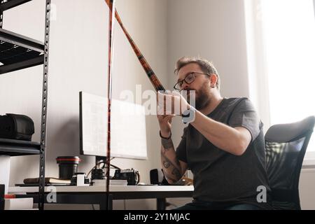 Fotograf untersucht Filmnegative in einem hellen Büro Stockfoto