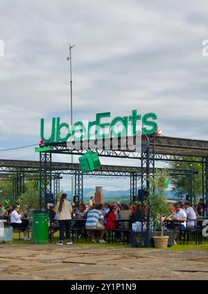 Sitzbereiche im Freien mit einem Schild für Sponsoren Uber Eats beim Champions Burger Food Event Magdalena Gardens Santander Cantabria Spanien Stockfoto