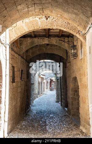 Enge Gasse (Agiou Fanouriou) mit Steinbögen im mittelalterlichen Stadtviertel Rhodos, Griechenland. Stockfoto