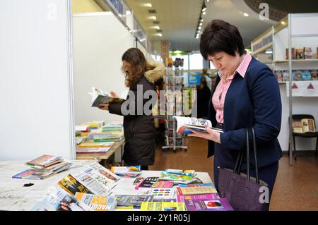 Kunden, die vor einem Bücherladen stehen und neue Bücher lesen. Buch Fair Book Verträge . Dezember 2017. Kiew, Ukraine Stockfoto