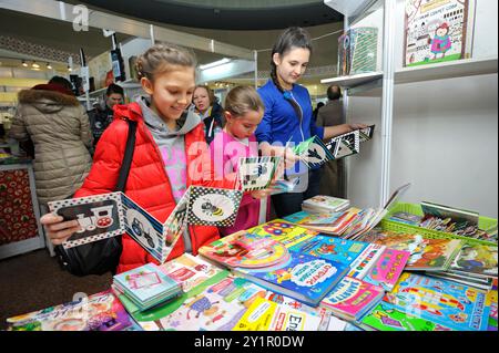 Kinder, die vor einem Bücherladen stehen und neu erschienene Kinderbücher lesen. Buch Fair Book Verträge . Dezember 2017. Kiew, Ukrainisch Stockfoto