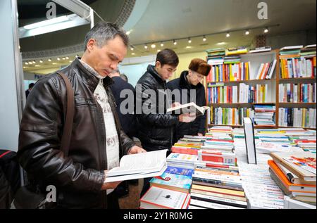 Kunden, die vor einem Bücherladen stehen und neue Bücher lesen. Buch Fair Book Verträge . Dezember 2017. Kiew, Ukraine Stockfoto