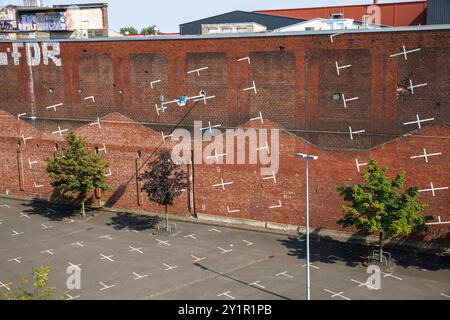 Gemalter vertikaler Parkplatz des Kölner Architekturprojektplans auf einer Backsteinmauer in der Nähe der Messe in Deutz, Köln. Aufgemalter vertikal Stockfoto