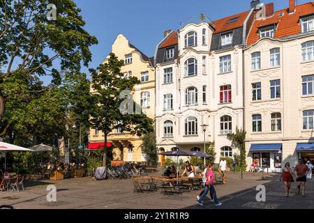 Straßencafés und Häuser auf dem Schill-Platz im Stadtteil Nippes, Köln, Deutschland. Strassencafes und Haeuser am Schillplatz im Stadtteil Nippes, Koe Stockfoto