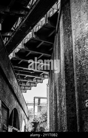 Unter dem Castlefield Railway Viaduct, Manchester UK im Juni, schwarz-weiß - viktorianisches Industrie- und Eisenbahnerbe, wie eine Kathedrale Stockfoto