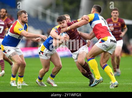 Huddersfield Giants’ Aidan McGowan wurde von Sam Davis und will Lovell aus London Broncos während des Spiels der Betfred Super League im John Smith's Stadium in Huddersfield angegriffen. Bilddatum: Sonntag, 8. September 2024. Stockfoto