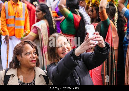 London, Großbritannien. September 2024. Bürgermeister von Lewisham, Brenda Dacres (links) und Labour-Abgeordneter von Lewisham North und Lord Commissioner of the Treasury, Vicky Foxcroft (rechts) nehmen an dem Festival Teil. Mehrere tausend Anhänger der tamilischen Gemeinde nehmen am jährlichen Chariot Festival (ther) vom Sivan Kovil Tempel durch die Straßen von Lewisham Teil. Die Götter Ganesha und Lord Shiva werden in dekorierten Wagen getragen. Die Gläubigen opfern Milch, verbrennen Weihrauch, Kokosnüsse oder Obst. Quelle: Imageplotter/Alamy Live News Stockfoto