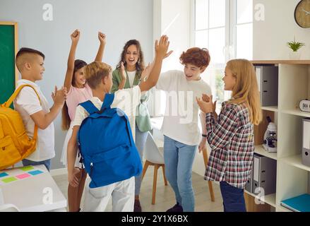 Eine Gruppe von freundlichen Schülern in der Klasse, die sich gegenseitig hochfiebern Stockfoto