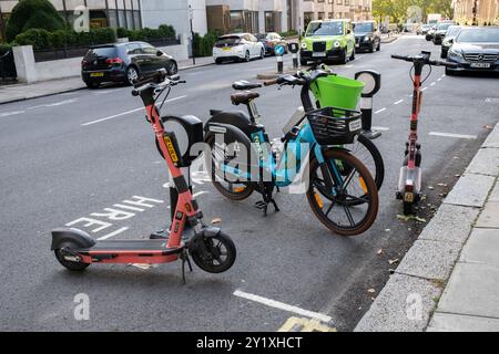 London, Großbritannien – 25. August 2024. Elektrofahrräder und Motorroller stehen auf einer Seitenstraße im Zentrum von London bereit und können gemietet werden Stockfoto
