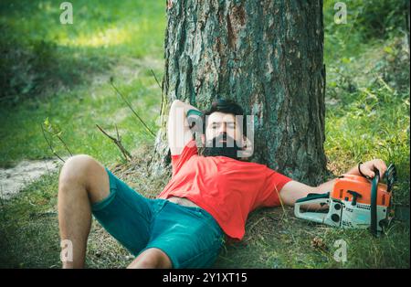 Holzfäller sitzt im Wald. Ruhe nach harter Arbeit. Stockfoto