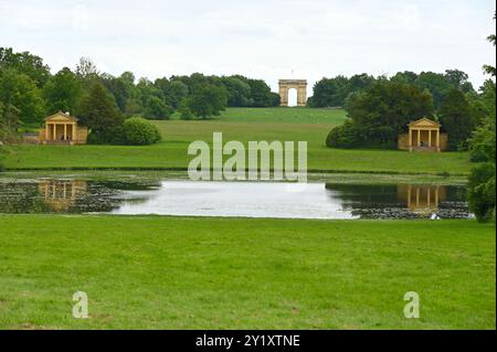 Blick über den Octagon Lake in Richtung Lake Pavilions und Corinthian Arch im Georgian Landscape Garden und Park National Trust Anlage in Stowe, Großbritannien Stockfoto