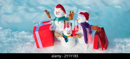 Weihnachtsbanner mit Schneemann. Glücklicher Schneemann mit Geschenk im Winter, schneebedeckt. Winterferien, Verkaufsbanner. Süßer Schneemann mit Hut und Schal Stockfoto