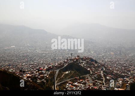 La Paz, BOLIVIEN; 8. September 2024: Rauch durch Waldbrände im bolivianischen Tiefland Amazonas und Yungas bedeckt die Stadt in einem dichten Dunst, der die nahe gelegenen Hügel und Berge verdeckt. Mehrere hundert Waldbrände brennen derzeit in der Tiefebene; Global Forest Watch hat im Jahr 2024 in Bolivien bisher 29.011 VIIRS-Brandalarme registriert (ein Rekord). Dieser Blick blickt ungefähr nach Osten über das Stadtzentrum in Richtung La Cumbre, dem Pass über die Anden auf der Hauptstraße zu den Yungas und den nördlichen Tiefländern. Stockfoto