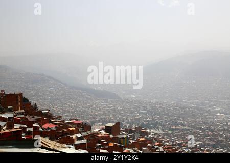 La Paz, BOLIVIEN; 8. September 2024: Rauch durch Waldbrände im bolivianischen Tiefland Amazonas und Yungas bedeckt die Stadt in einem dichten Dunst, der die nahe gelegenen Hügel und Berge verdeckt. Mehrere hundert Waldbrände brennen derzeit in der Tiefebene; Global Forest Watch hat im Jahr 2024 in Bolivien bisher 29.011 VIIRS-Brandalarme registriert (ein Rekord). Dieser Blick blickt nordöstlich über die Hügel der Stadt in Richtung Achachicala-Tal und der Anden; an klaren Tagen wäre der 6088 m/975 Fuß hohe Berg Huayna Potosí deutlich sichtbar (Sie können nur den Gipfel oben in der Mitte sehen). Stockfoto