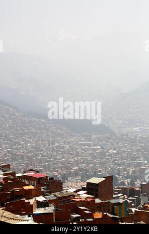 La Paz, BOLIVIEN; 8. September 2024: Rauch durch Waldbrände im bolivianischen Tiefland Amazonas und Yungas bedeckt die Stadt in einem dichten Dunst, der die nahe gelegenen Hügel und Berge verdeckt. Mehrere hundert Waldbrände brennen derzeit in der Tiefebene; Global Forest Watch hat im Jahr 2024 in Bolivien bisher 29.011 VIIRS-Brandalarme registriert (ein Rekord). Dieser Blick blickt nordöstlich über die Hügel der Stadt in Richtung Achachicala-Tal und der Anden; an klaren Tagen wäre der 6088 m/975 Fuß hohe Berg Huayna Potosí deutlich sichtbar (Sie können nur den Gipfel oben in der Mitte sehen). Stockfoto