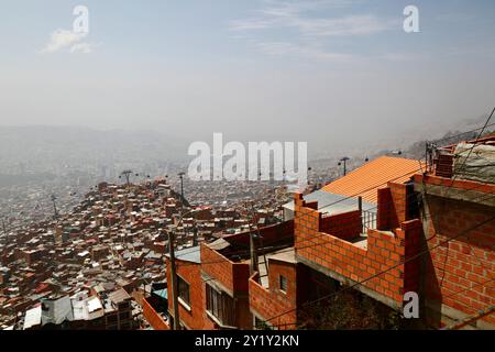 La Paz, BOLIVIEN; 8. September 2024: Rauch durch Waldbrände im bolivianischen Tiefland Amazonas und Yungas bedeckt die Stadt in einem dichten Dunst, der die nahe gelegenen Hügel und Berge verdeckt. Mehrere hundert Waldbrände brennen derzeit in der Tiefebene; Global Forest Watch hat im Jahr 2024 in Bolivien bisher 29.011 VIIRS-Brandalarme registriert (ein Rekord). Dieser Blick blickt nach Südosten über die Stadtvororte in Richtung des unteren Teils der Stadt Zona Sur, normalerweise Mt. Illimani, Boliviens zweithöchster Gipfel, wäre in dieser Ansicht deutlich zu sehen. Stockfoto