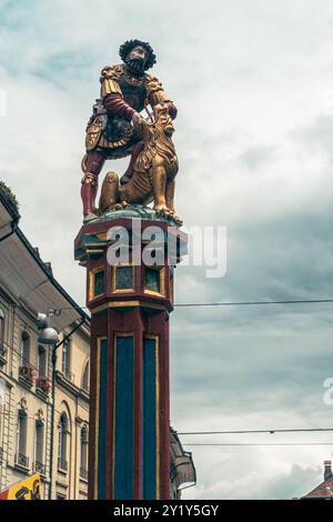 Bern, Schweiz - 22. Juli 2024: Der Simsonbrunnen Brunnen zeigt einen biblischen samson, der einen Löwen tötet, in der überfüllten Marktgasse, einer der Hauptstraßen Stockfoto